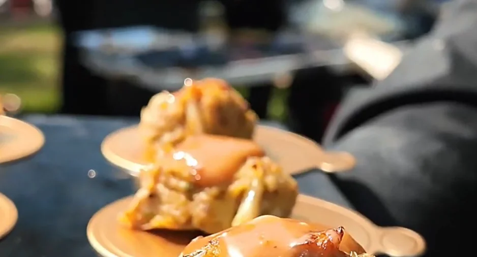 Crab cakes with sauce on golden plates at an outdoor event