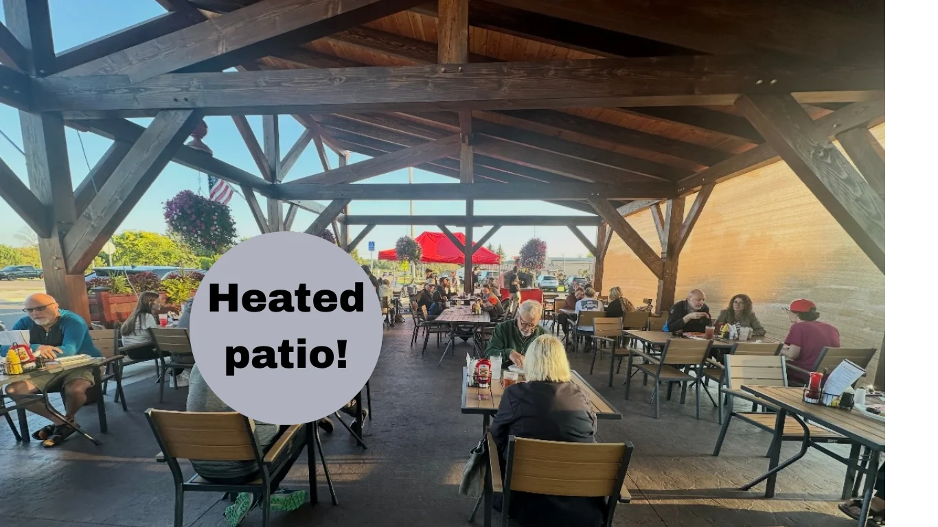 Outdoor patio dining area with tables and umbrellas at a restaurant.