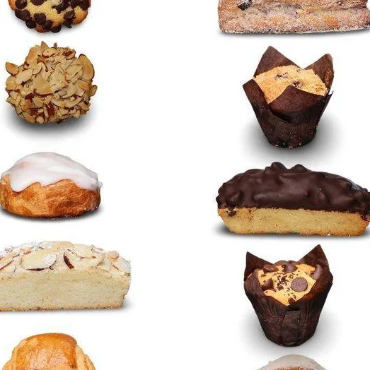 An assortment of baked goods including croissants, cookies, and pastries arranged above a white box.