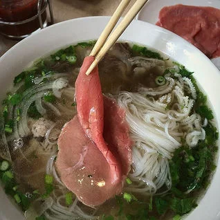 Bowl of Vietnamese pho with beef and fresh herbs