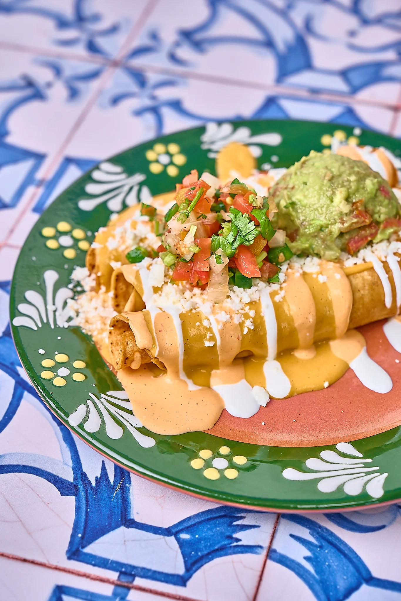 Delicious Mexican taquitos topped with guacamole and salsa