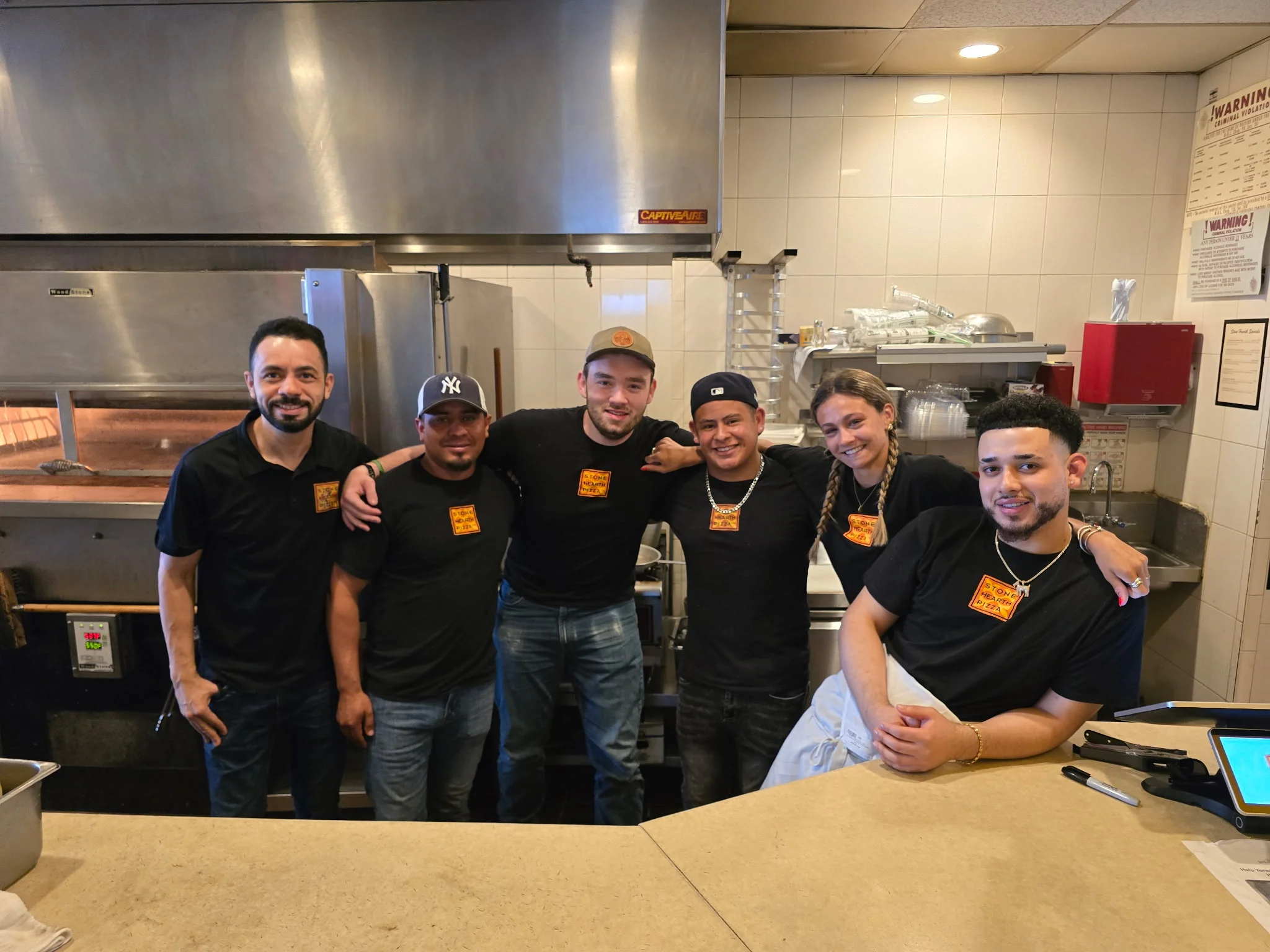 Friendly restaurant staff posing in a vibrant kitchen