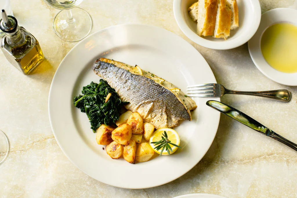 Grilled Mediterranean sea bass with roasted potatoes and greens
