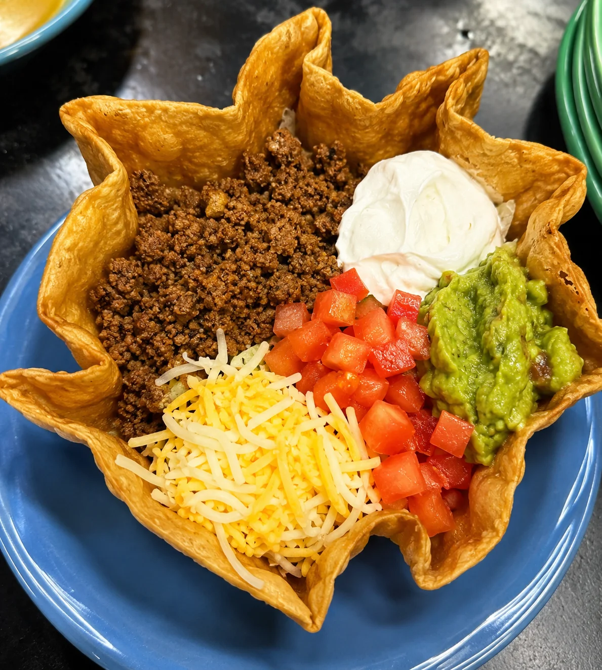 Taco salad in a crispy tortilla bowl with toppings