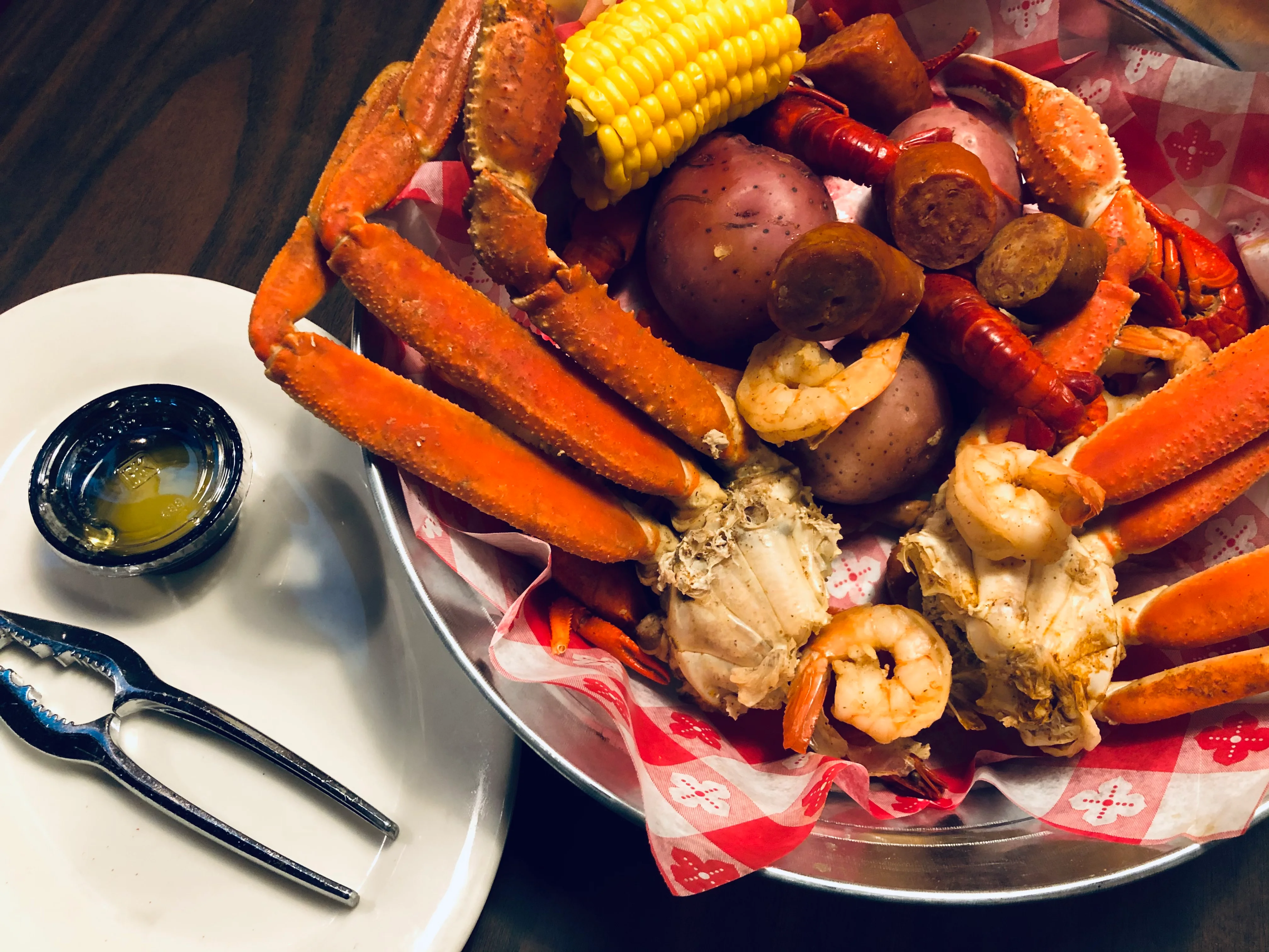 Seafood boil with crab, shrimp, and sausage served in a metal bowl