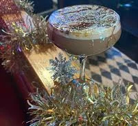 Festive cocktail garnished with chocolate and snowflake decor