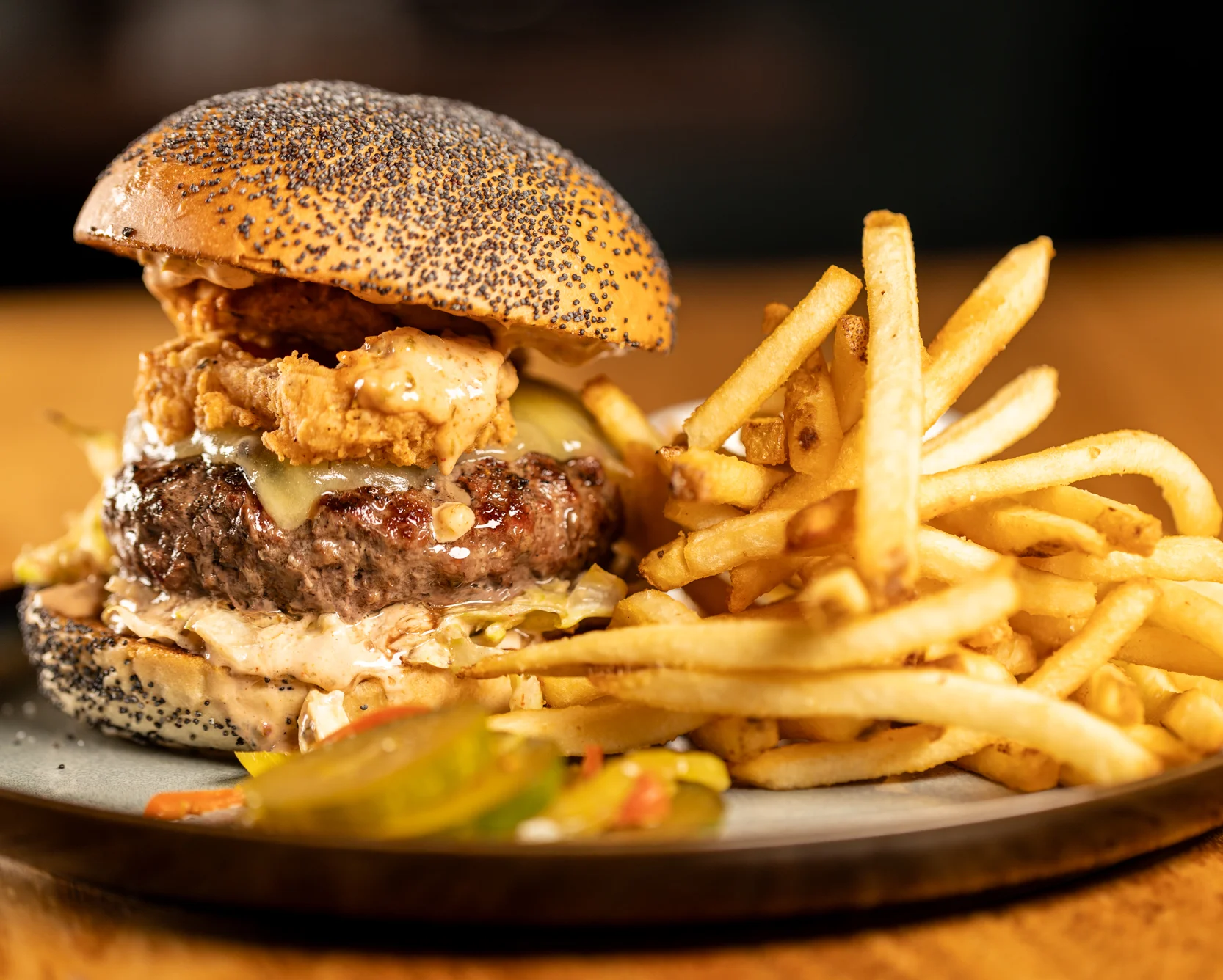 hamburger with onion ring and stacked fries