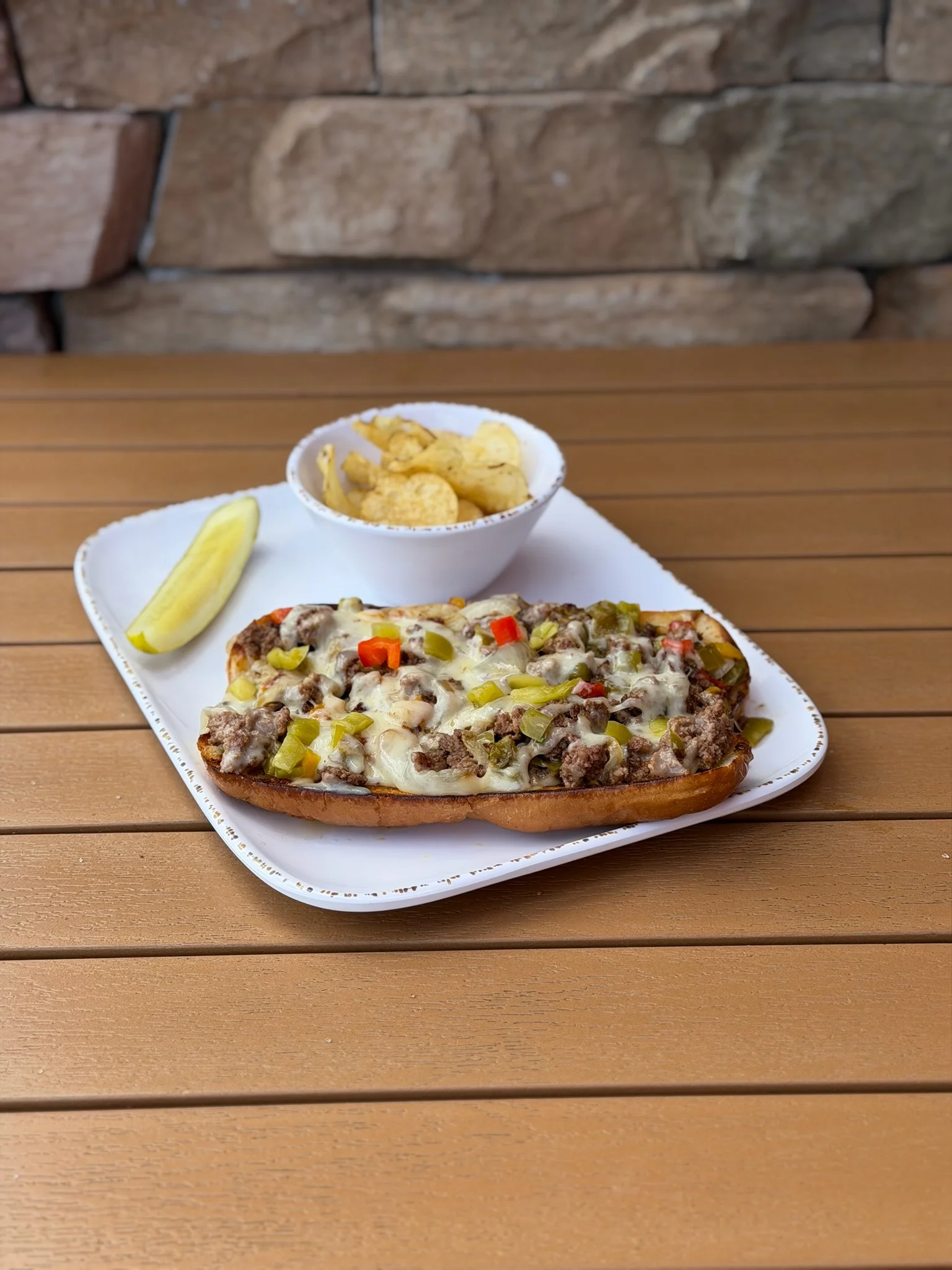 Cast iron skillet with a colorful vegetable and cheese dish, served with lettuce and tomato.
