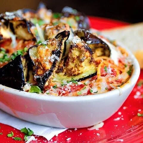 Baked eggplant parmesan served in a rustic bowl