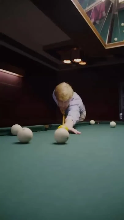 Young player focusing on a billiards shot on a green felt table