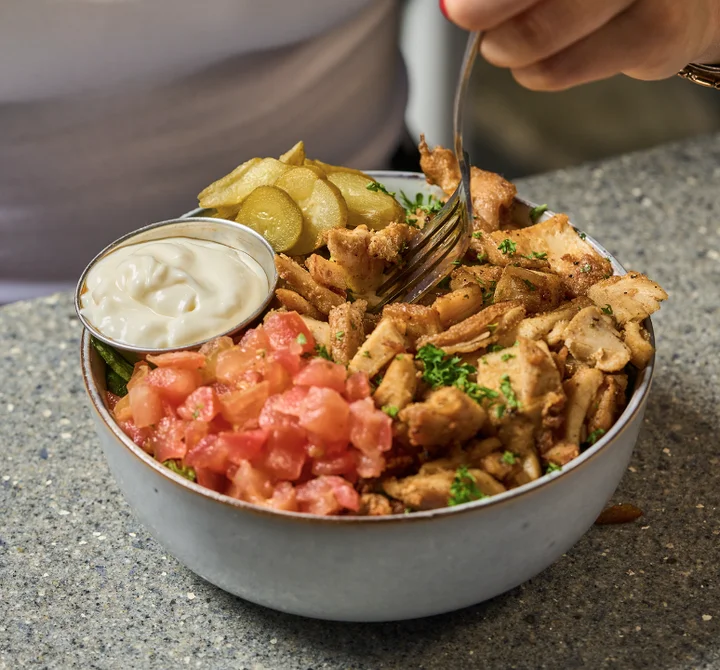 A healthy bowl of grilled chicken served with vegetables.