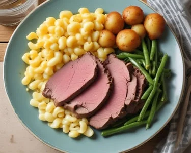 Plate of sliced roast beef, macaroni, green beans, and baby potatoes.