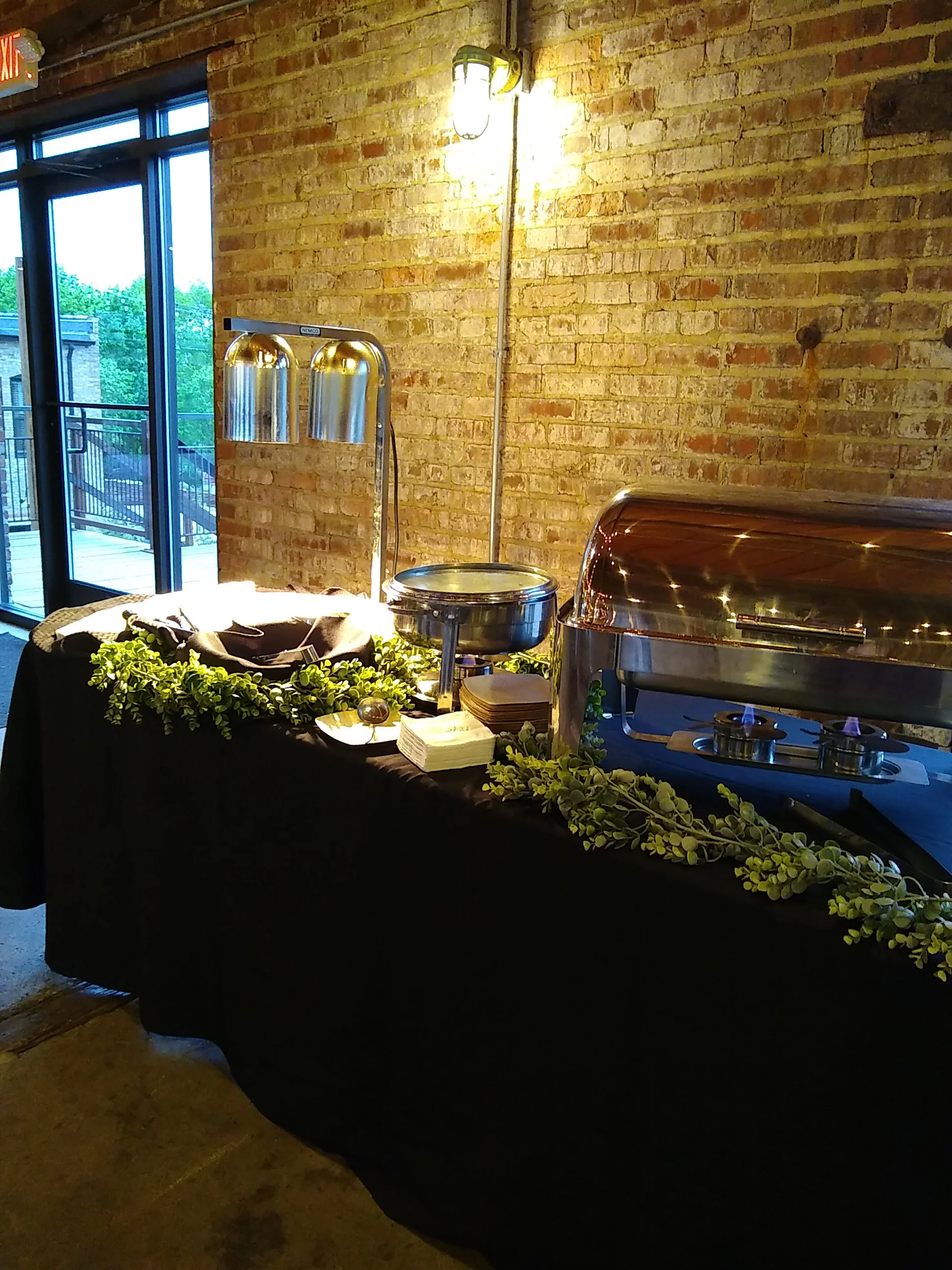 Elegant buffet setup with warm lighting and greenery accents