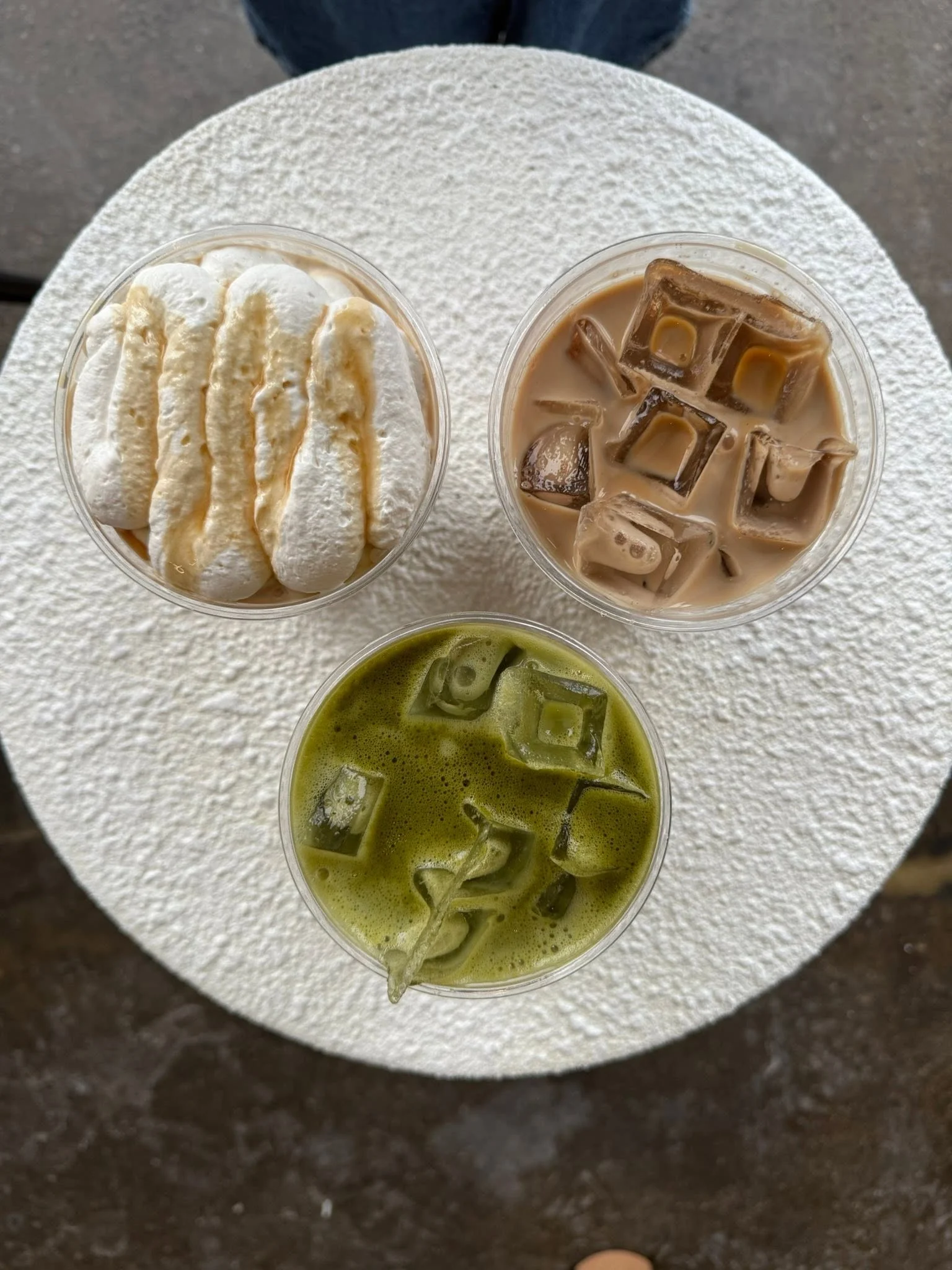 Three iced beverages: matcha latte, coffee with cream, and a sweet dessert drink