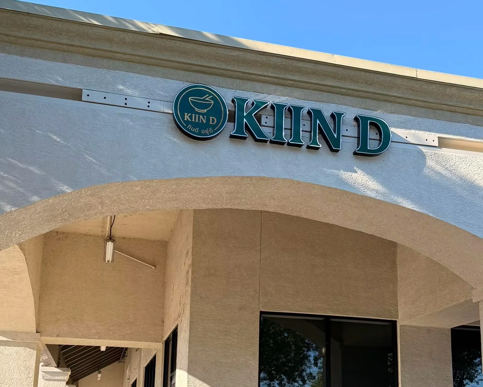 Exterior view of KIIN D restaurant with modern signage