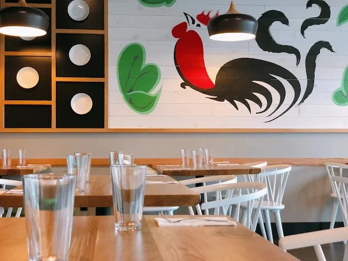A logo displaying the name of a Thai restaurant with a stylized depiction of a rooster and steam rising from a bowl.