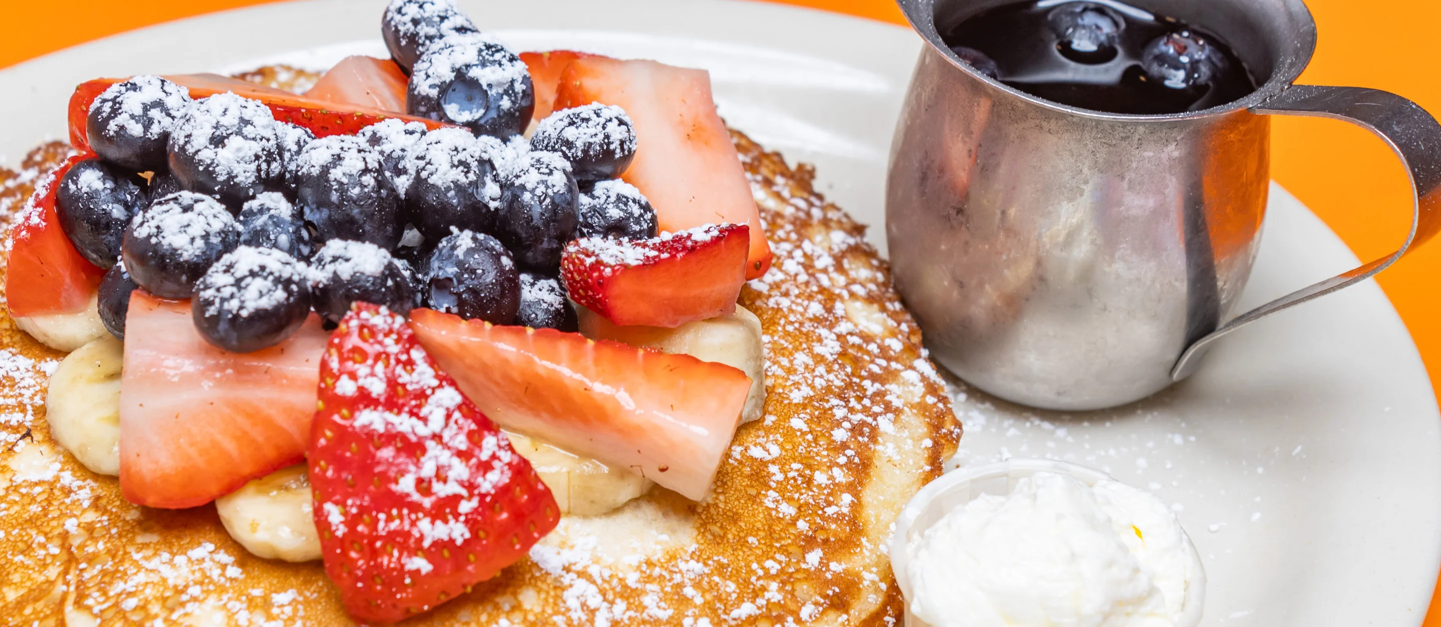 Fluffy pancakes topped with fresh berries and whipped cream