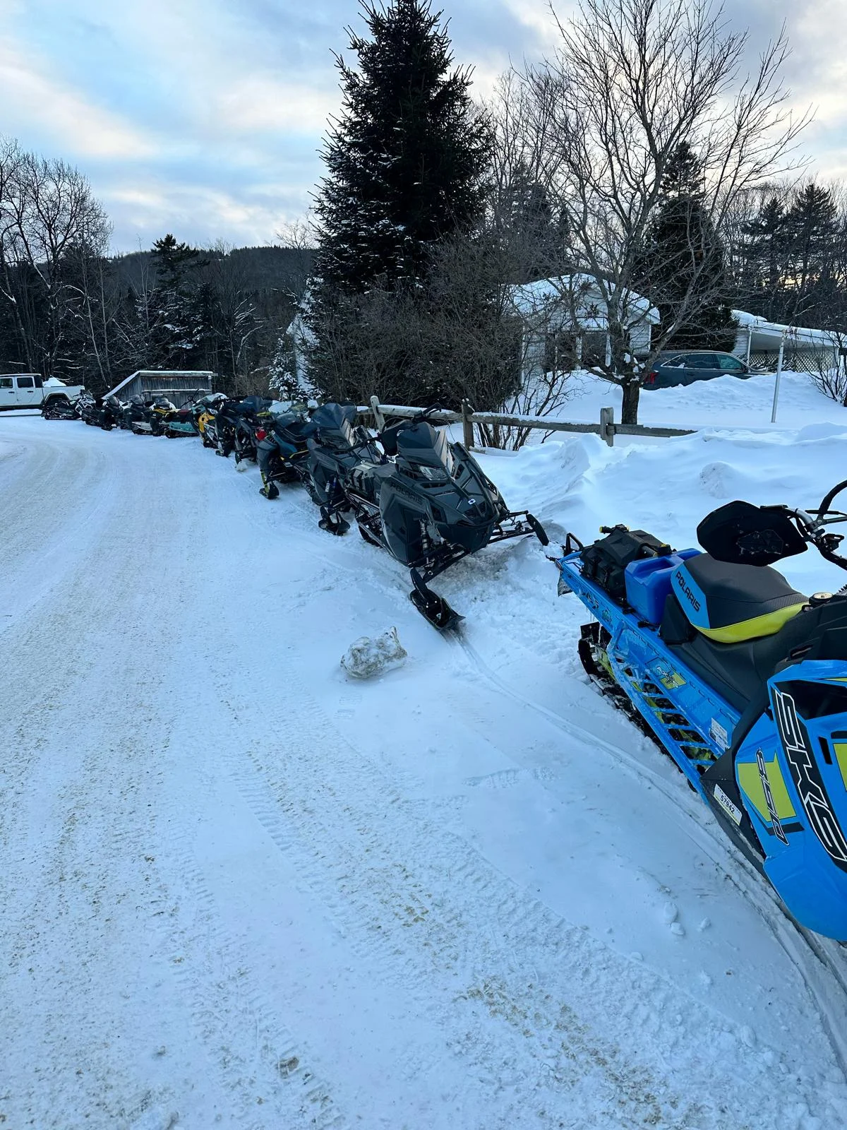 Row of snowmobiles parked in a snowy landscape