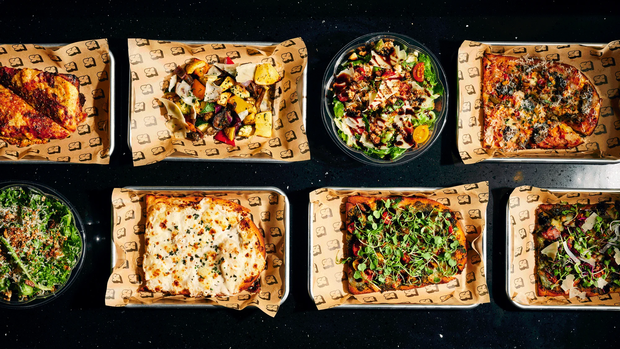 Assorted gourmet pizzas and salads in a modern restaurant setting