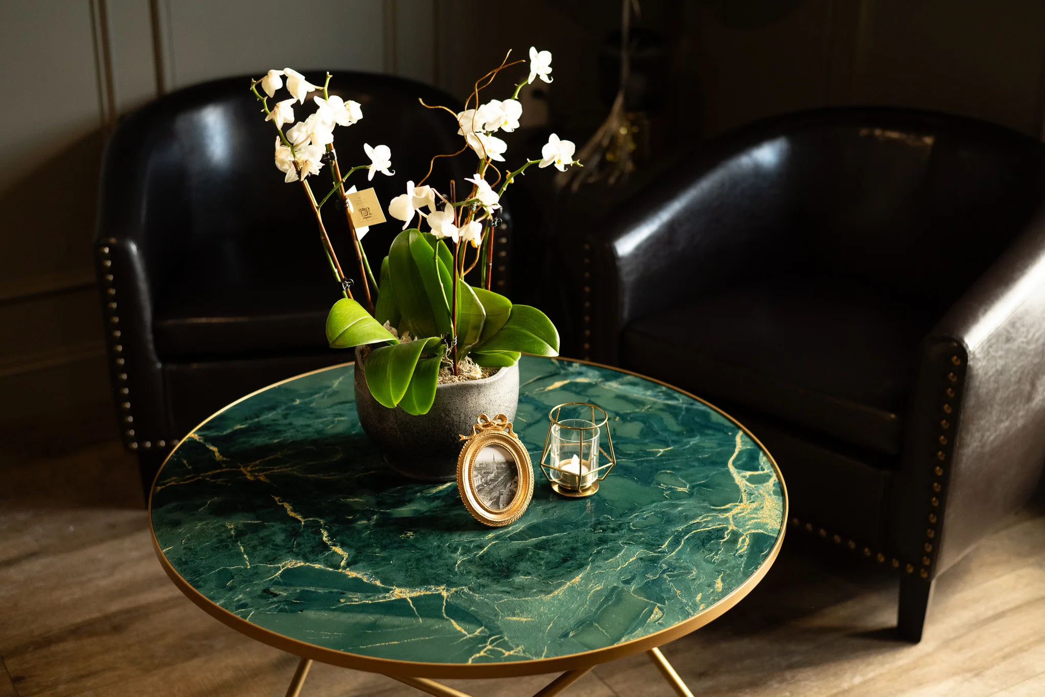 Elegant seating area with green marble table and white orchids