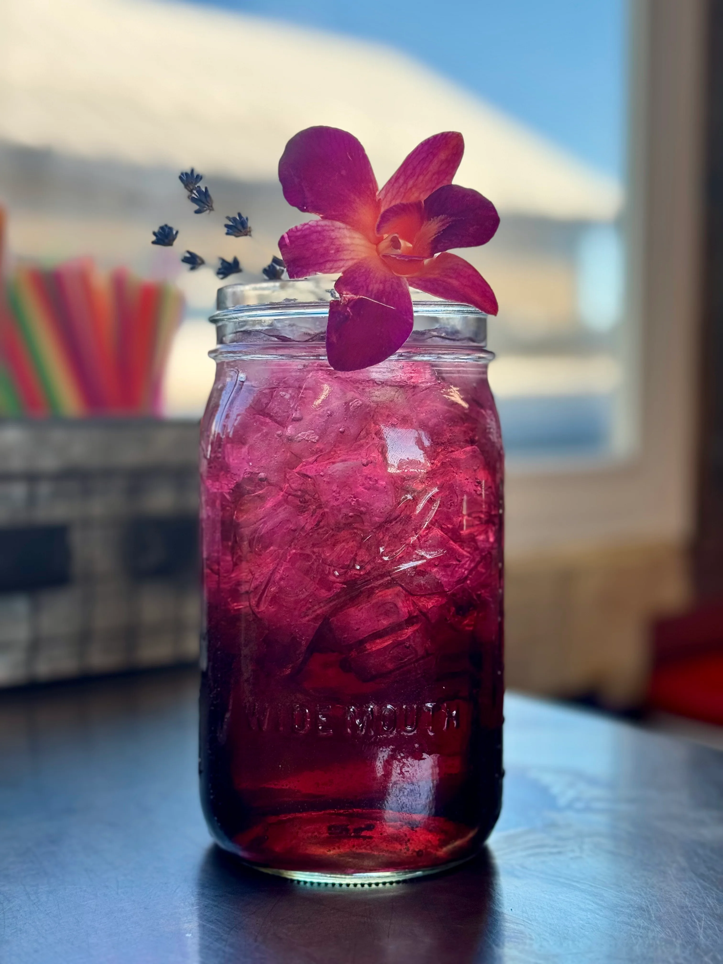 Colorful floral cocktail in a mason jar with ice