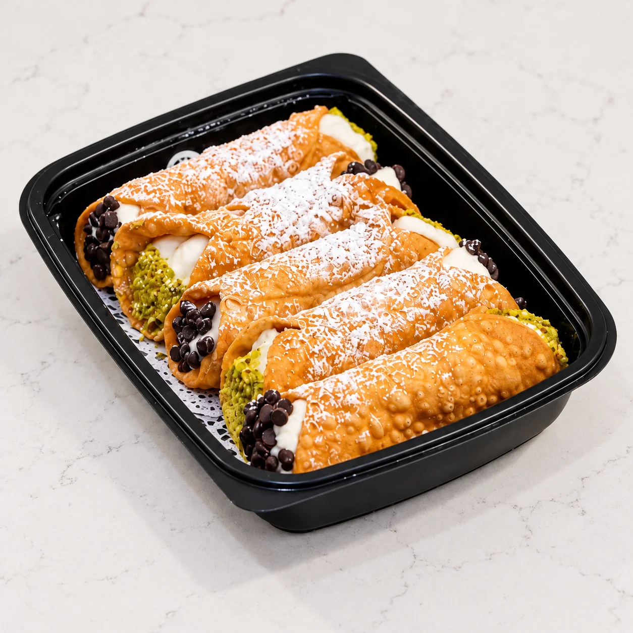 Cannoli catering tray with sweet ricotta cream, chocolate chips, and pistachios