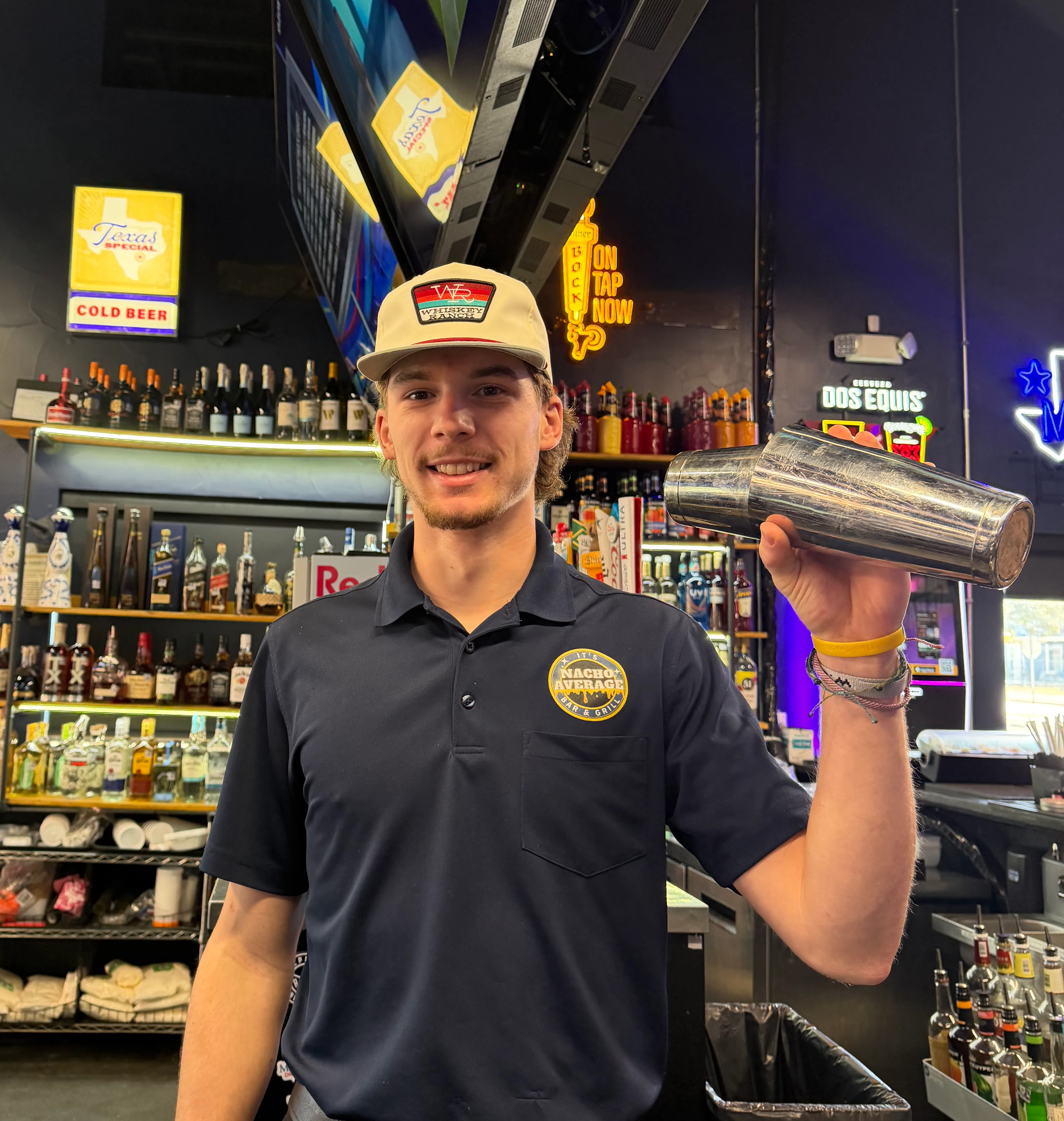Bartender showcasing a cocktail shaker at a vibrant bar