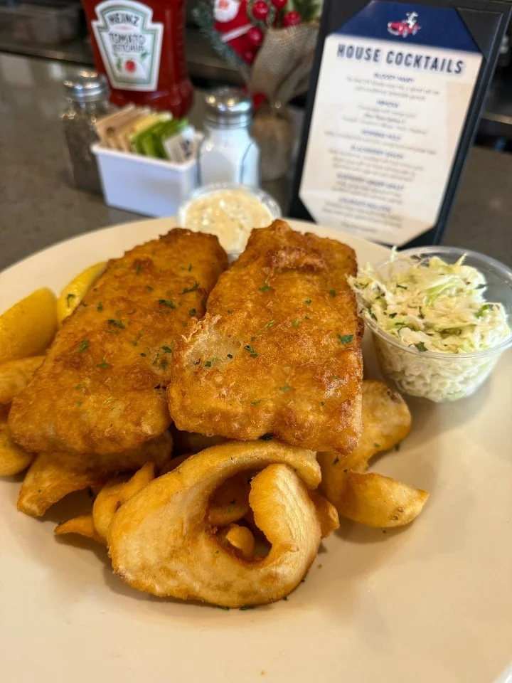 Cow Famous Fish n' Chips - Two beer battered Alaskan Pollock fillets served with fries, tartar, slaw and lemon!