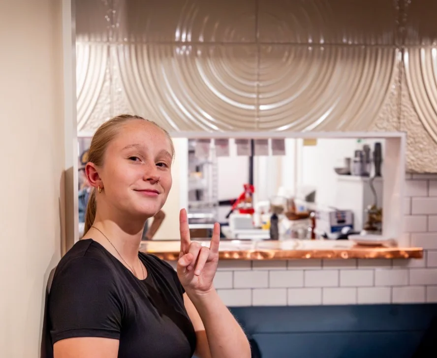 Young server posing in a modern restaurant interior