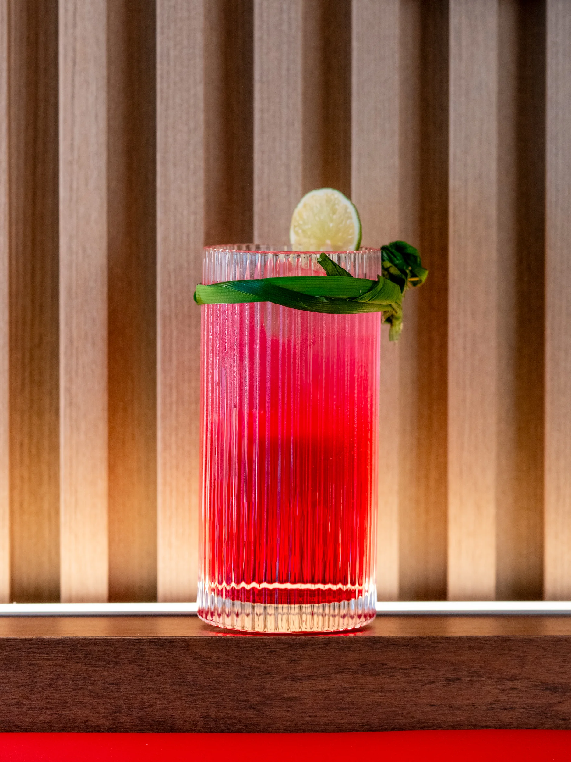 Vibrant cocktail garnished with lime and herbs