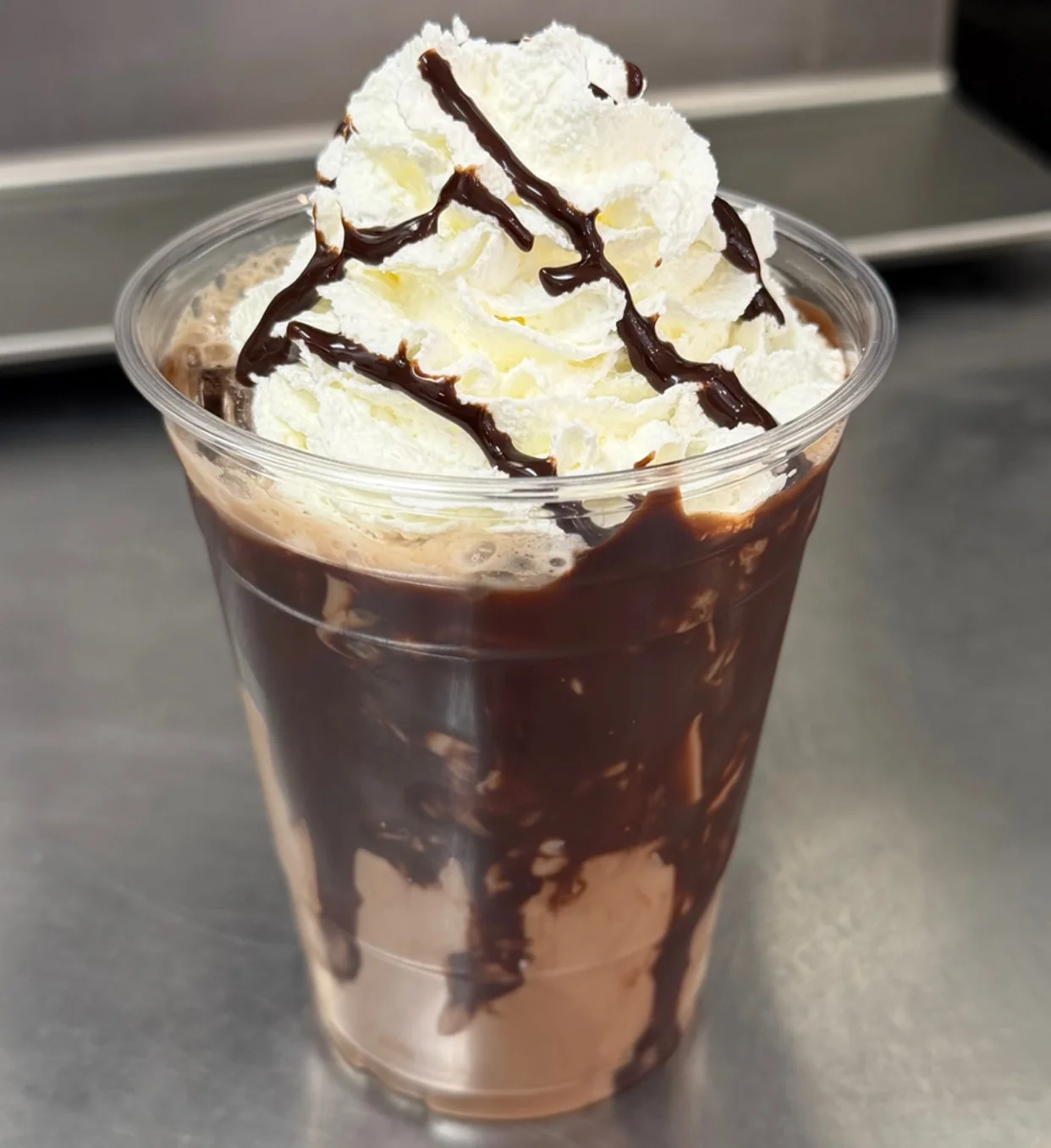 Iced mocha topped with whipped cream and chocolate drizzle