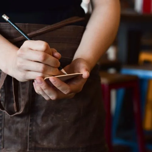 Waitstaff taking notes in a cozy restaurant setting
