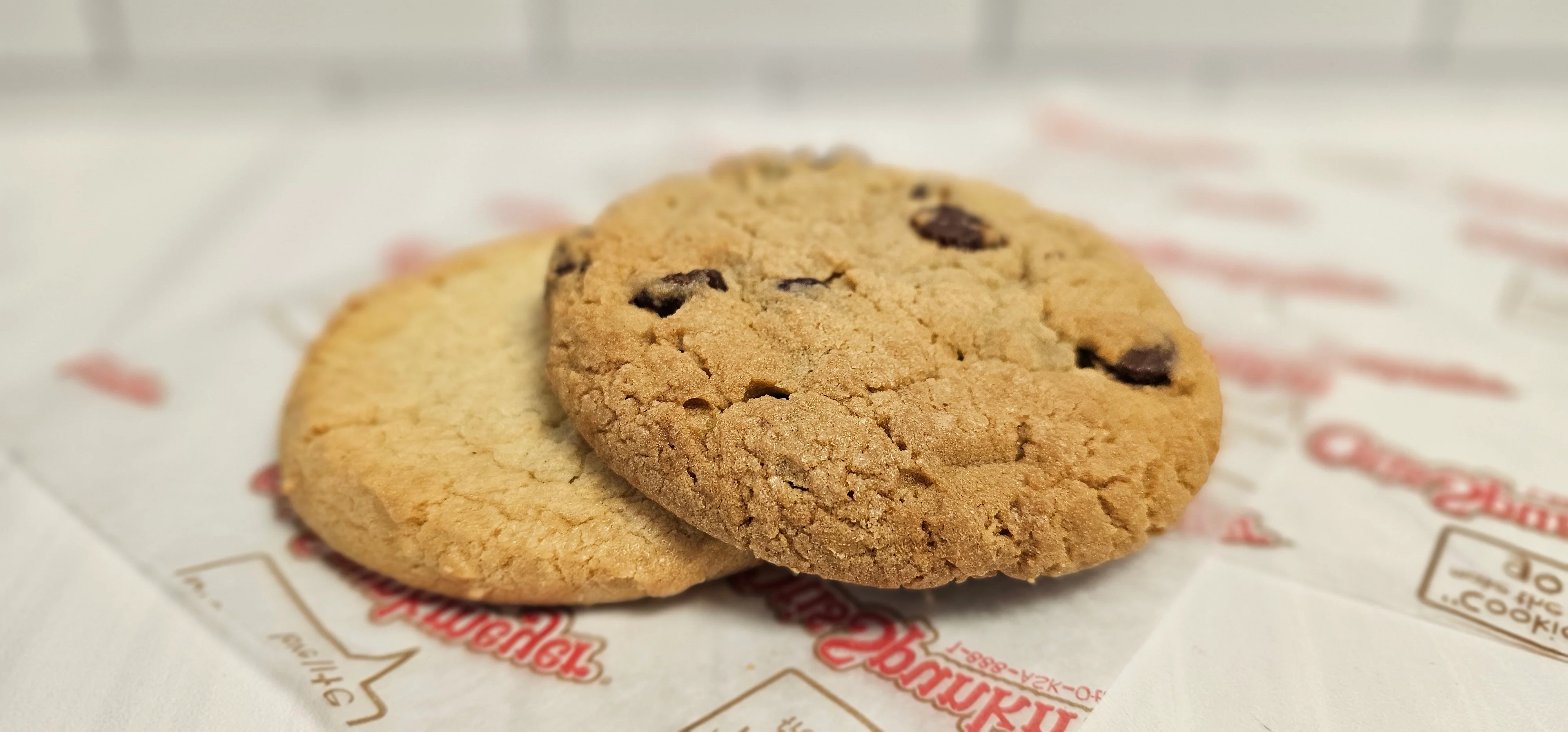 Freshly baked chocolate chip cookies on parchment paper