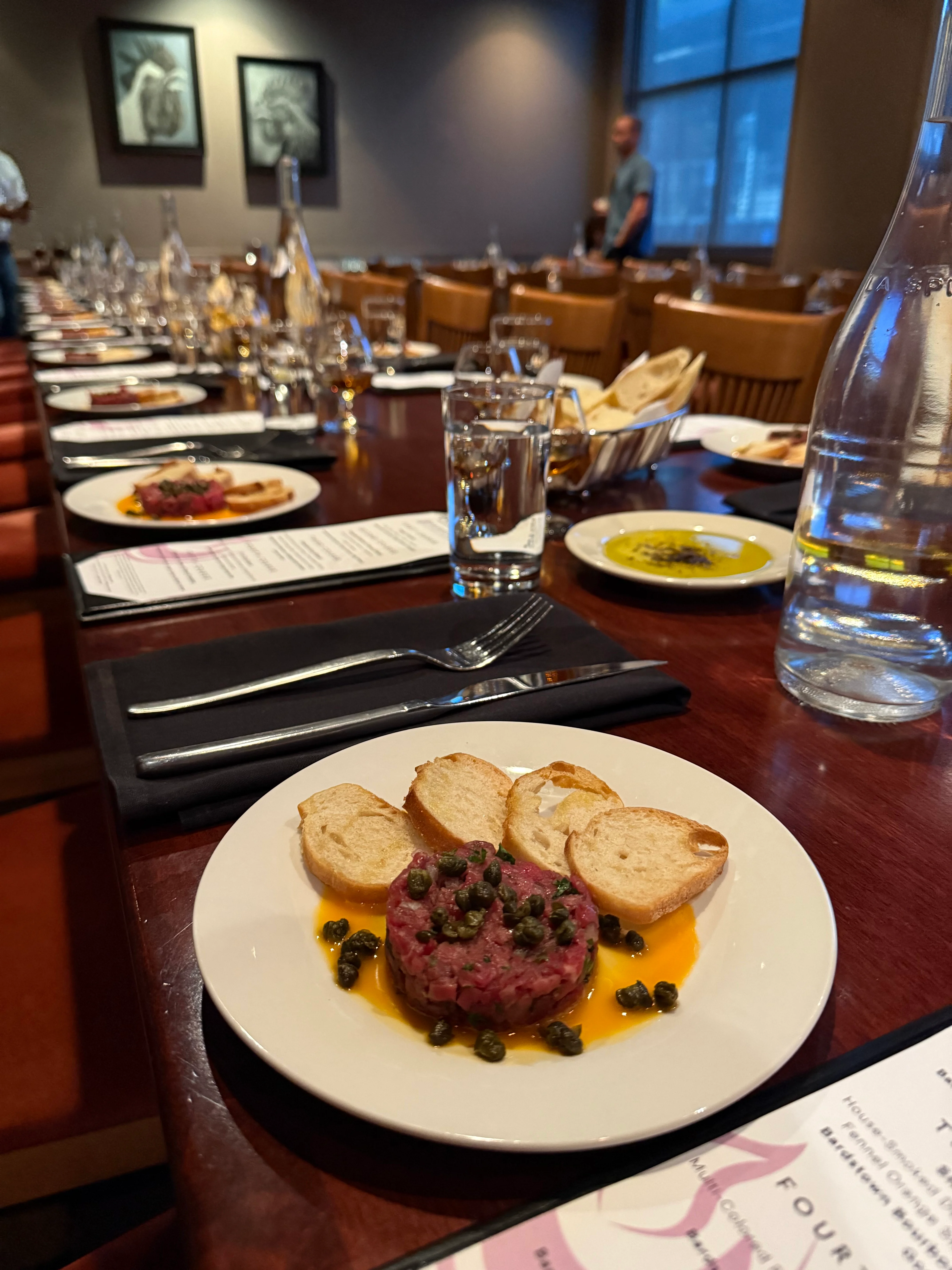 Beef tartare served with crostini in a modern restaurant setting