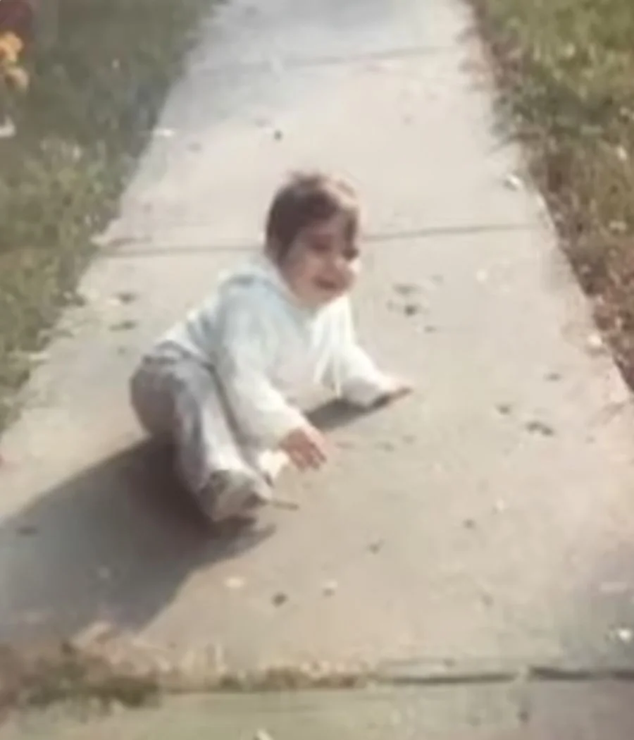 Baby crawling on a sidewalk in a sunny outdoor setting