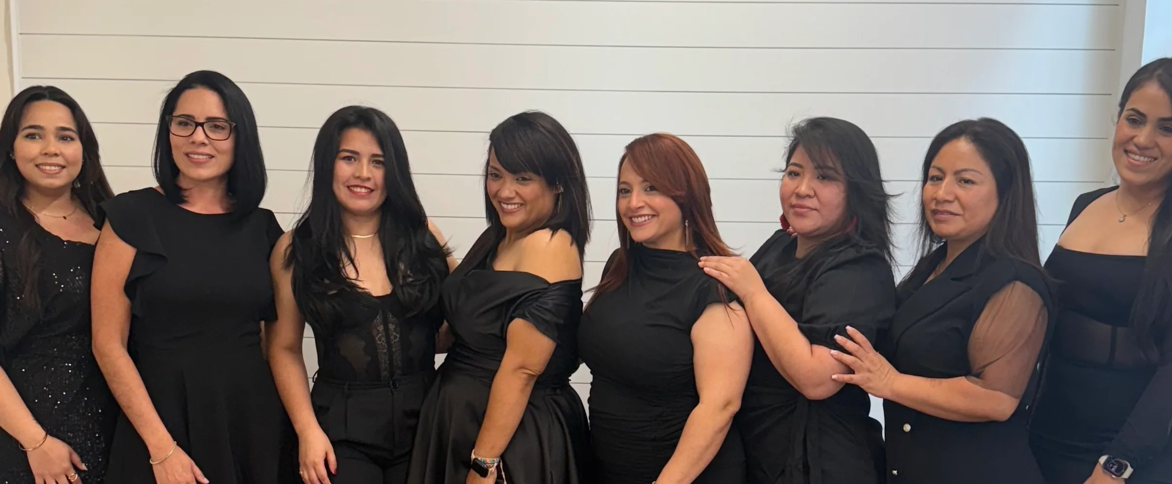 Group of women in stylish black outfits posing together