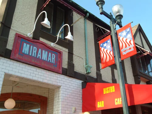 Exterior view of Miramar Bistro with signage and decorative banners