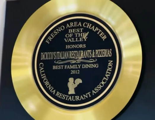 A plaque displaying an award for best family dining, featuring a gold circular design with details of the honor.