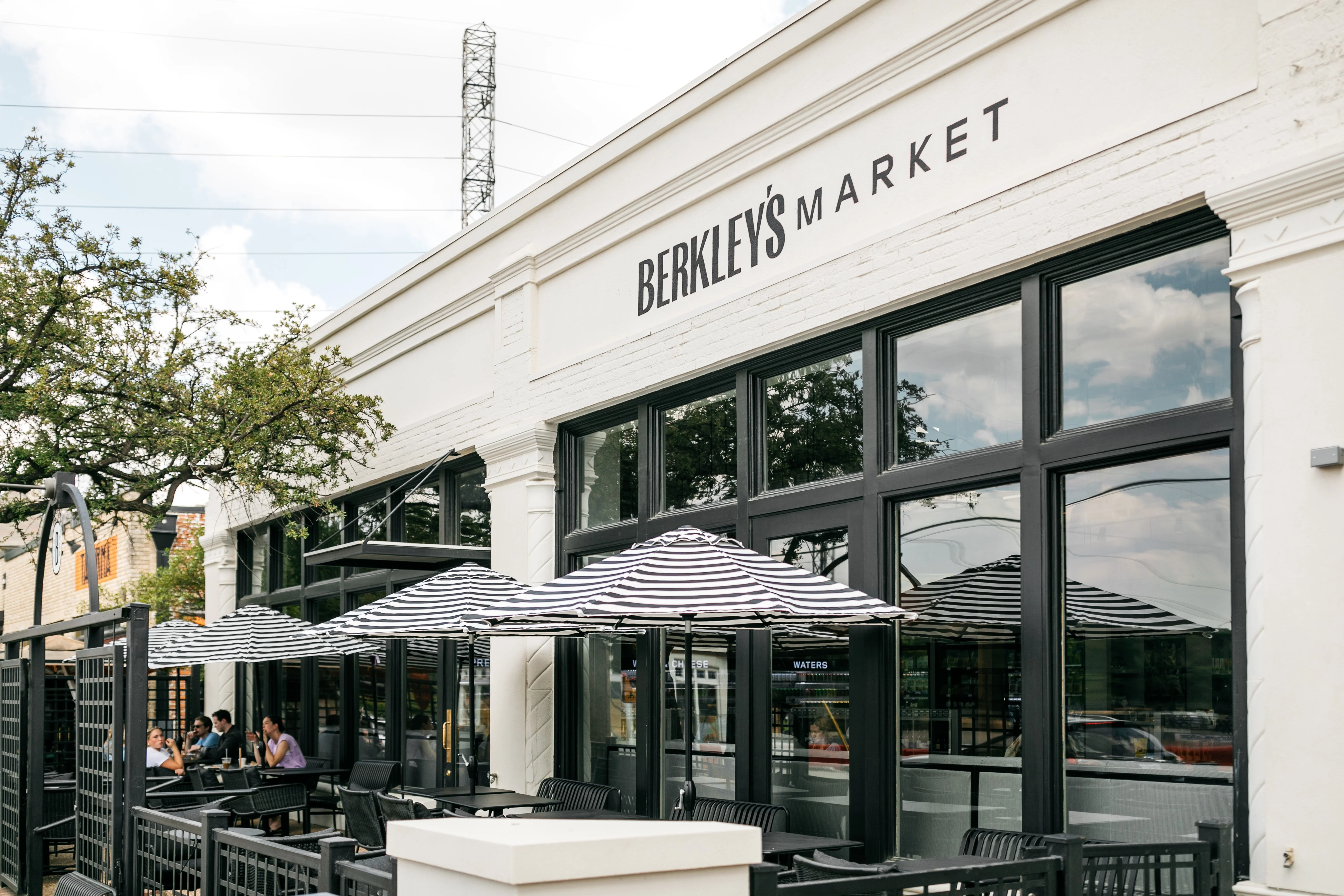 Exterior view of Berkley's Market with outdoor seating and striped umbrellas