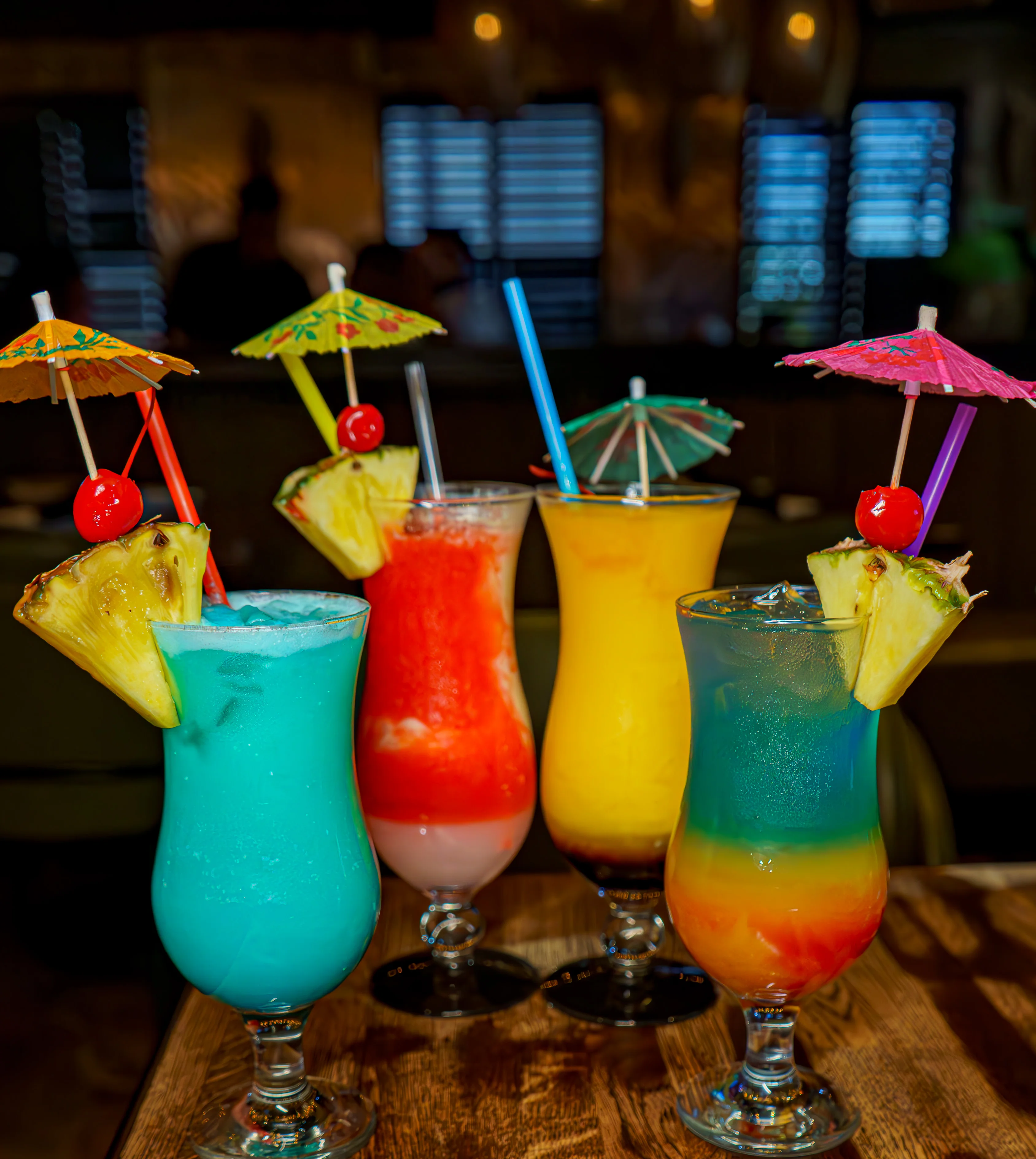 Colorful tropical cocktails with umbrellas and fruit garnishes