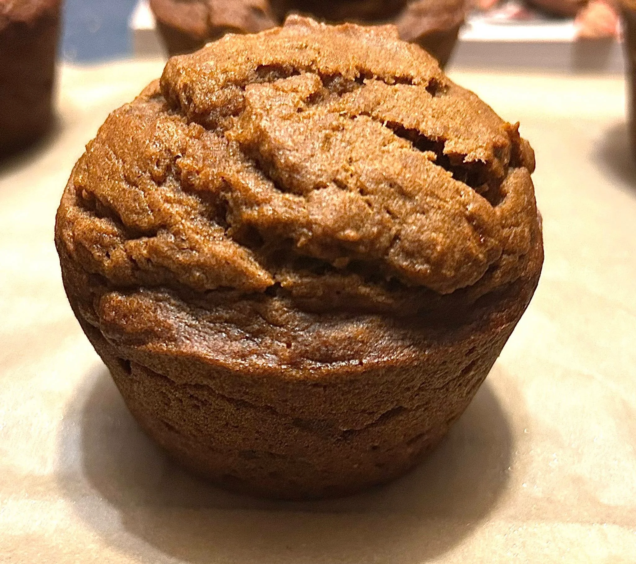 Freshly baked pumpkin muffin on parchment paper