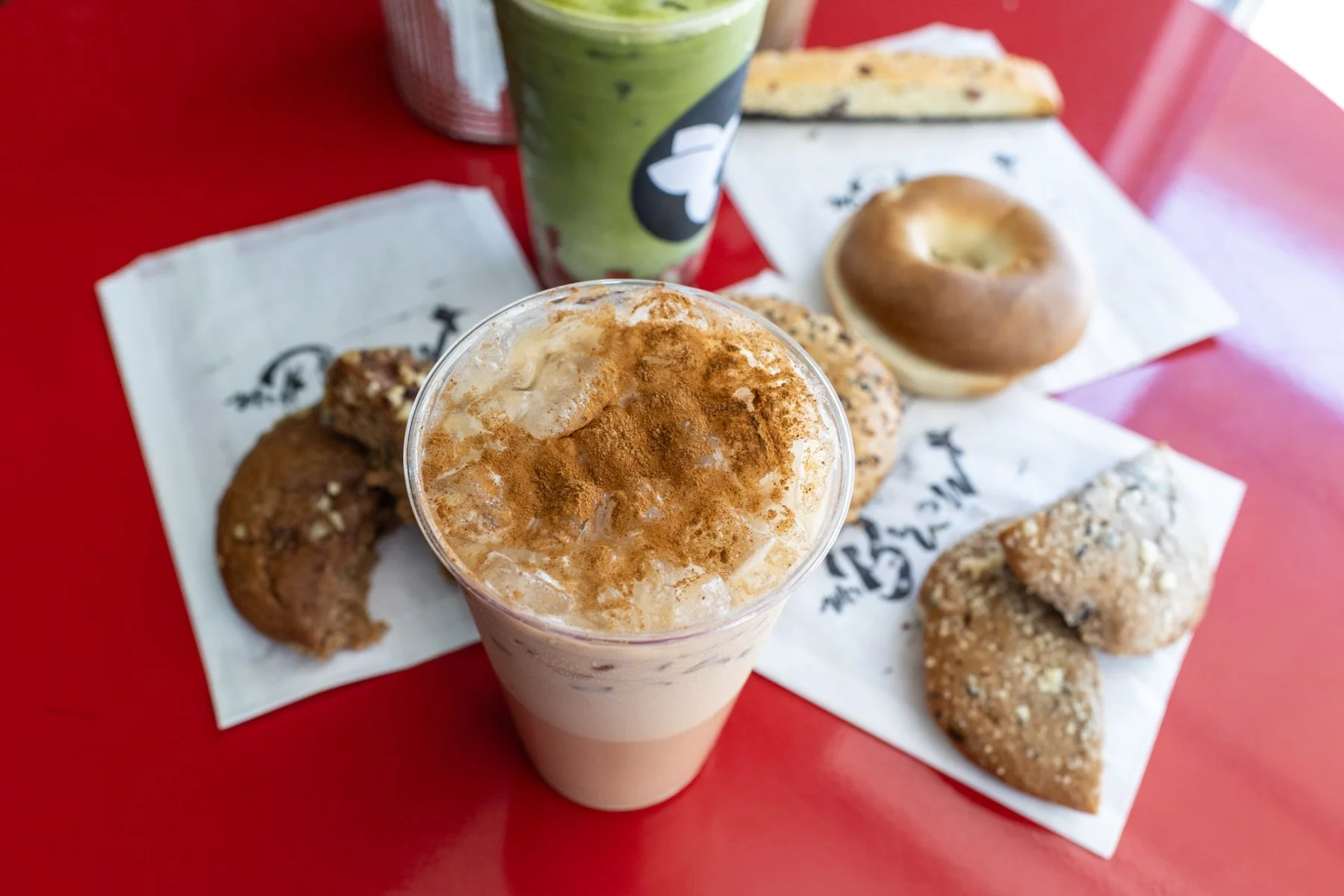 Iced coffee topped with cinnamon and assorted baked goods