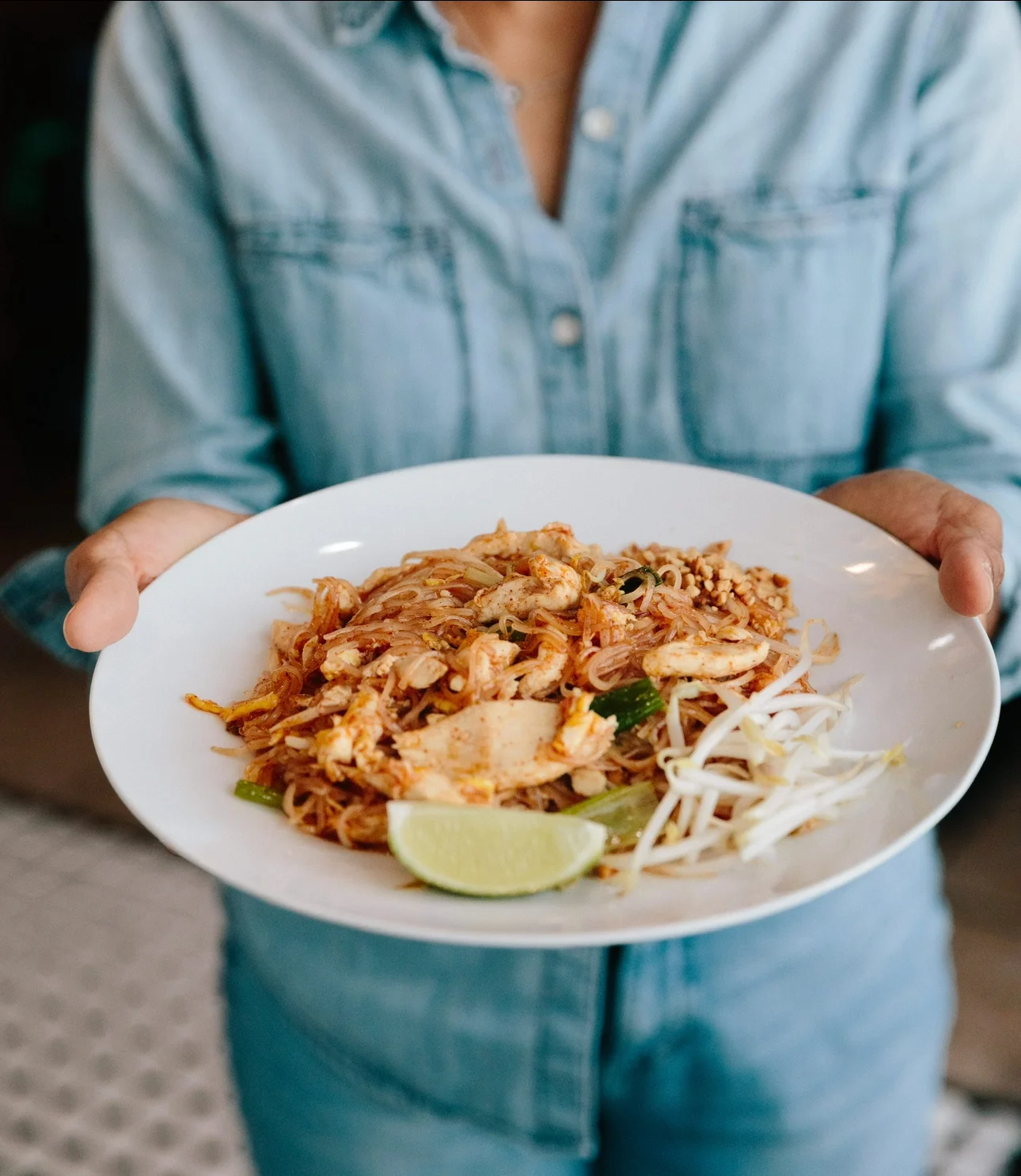 Plate of Thai pad thai with chicken and lime