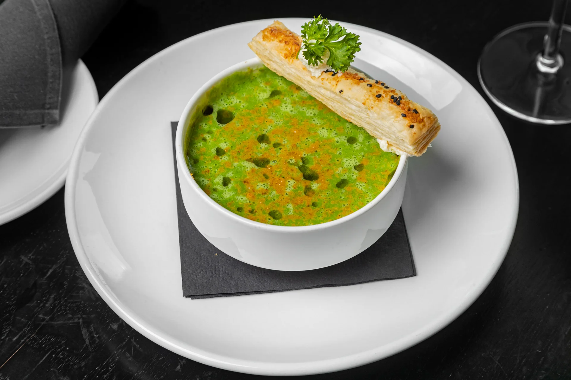 Vibrant bowl of Indian palak soup with crispy breadstick