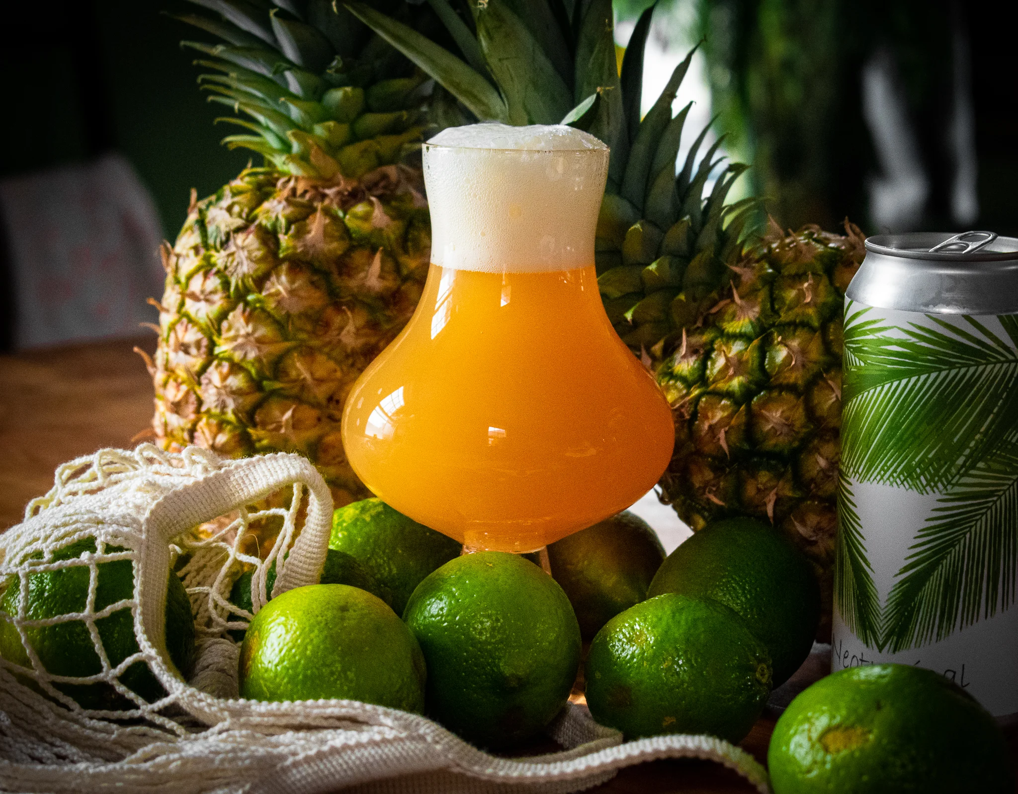Craft beer in a glass with limes and pineapples
