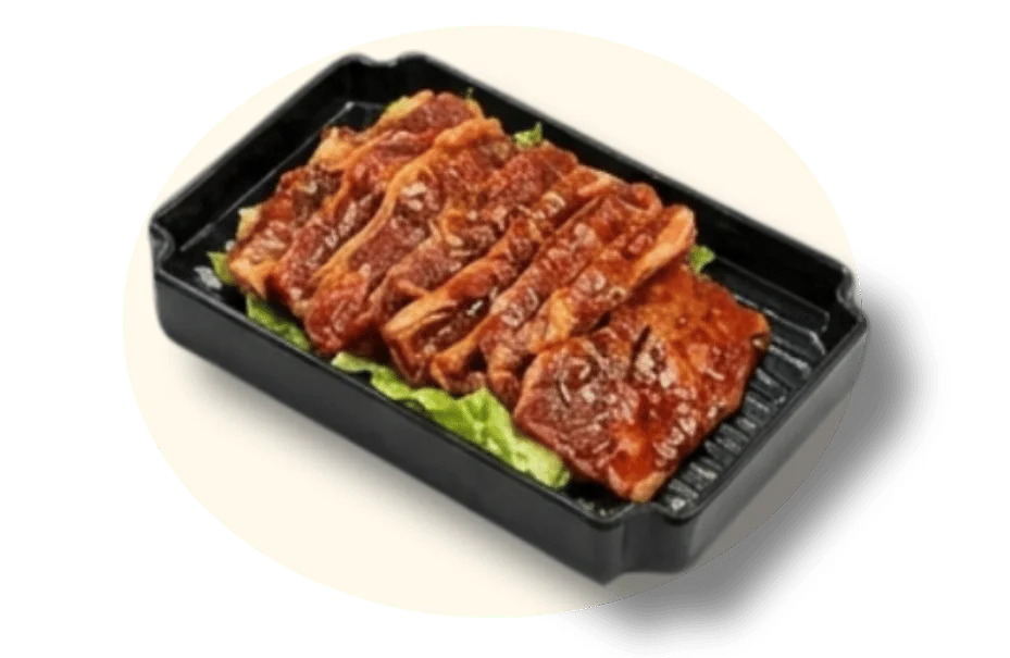 Grilled marinated meat slices on a bed of lettuce in a black tray.