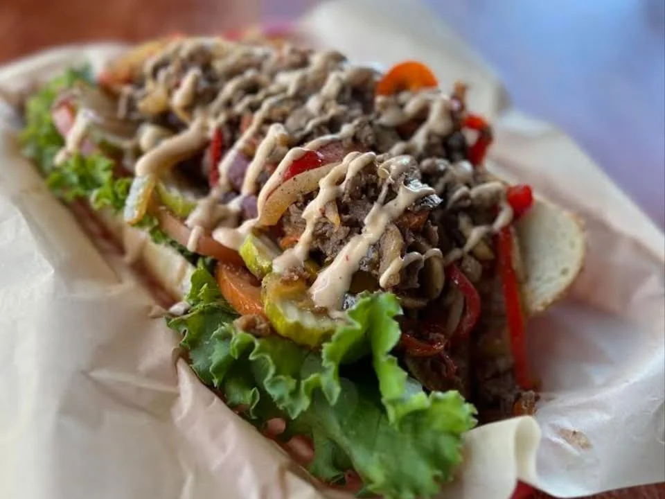 Delicious gourmet burger with fresh toppings on a wooden table.