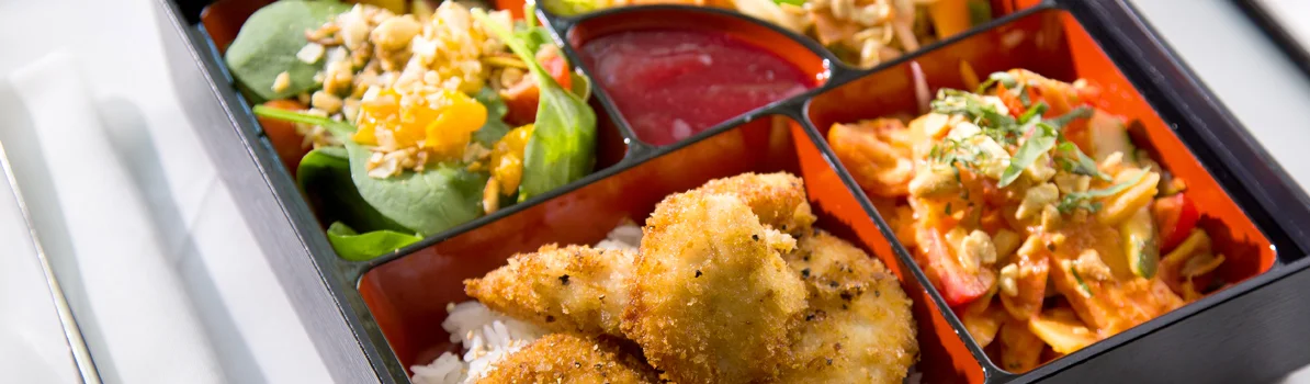 Japanese bento box with fried fish and colorful sides