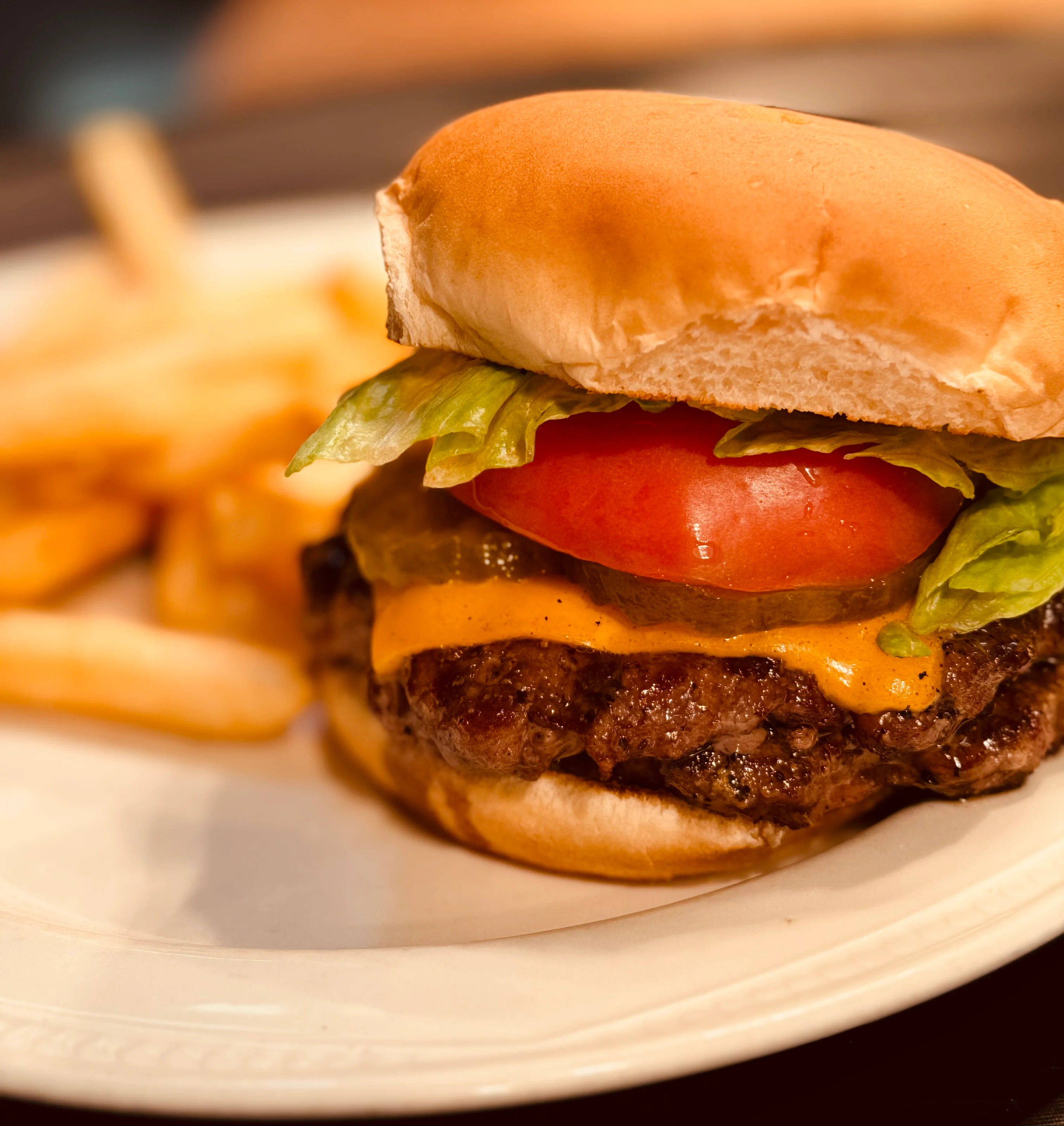 Classic American cheeseburger with fries on a white plate