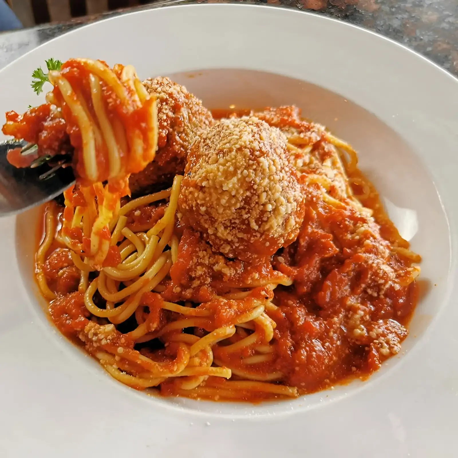 Spaghetti topped with homemade meatballs, marinara sauce, and grated Parmesan cheese.